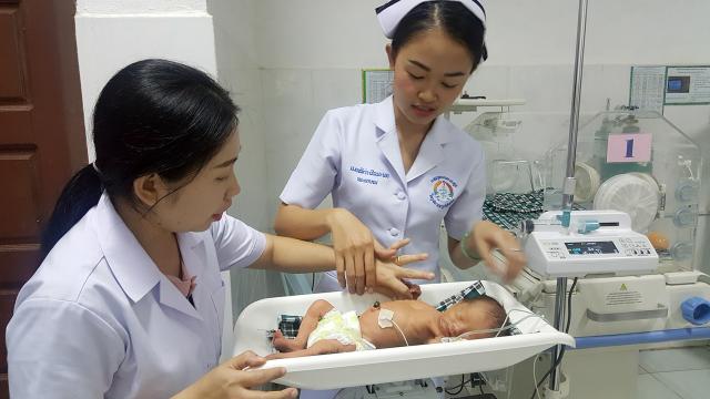 A nurse shows a student what to do after the first birth at Bolikhamxay Hospital