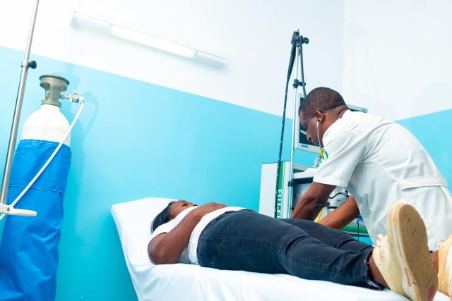 Homme auscultant une femme sur un lit dans un hôpital