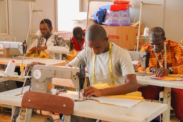 Jeunes hommes apprenant la couture