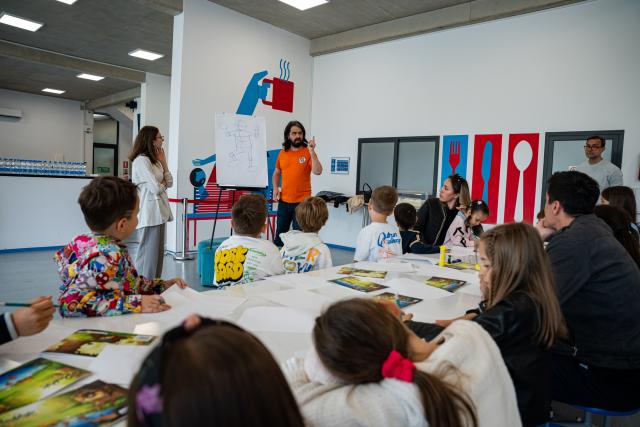 A lecturer explaining illustrations to elementary school kids as part of GRAN Fest