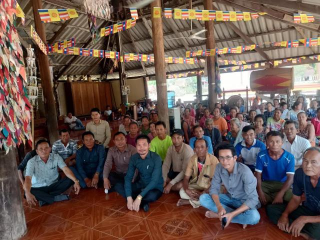 Villagers at the meeting with temple flags