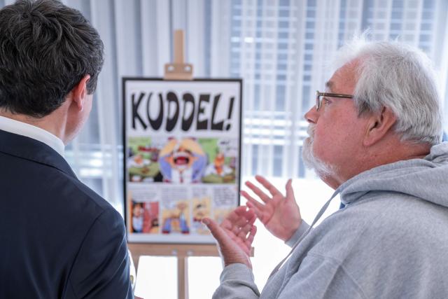 Artists explaining comic illustrations to acting Prime Minister Albin Kurti 