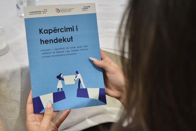 Person holding a brochure in hand