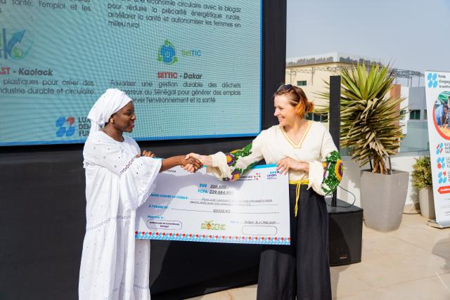 Remise d'un chèque symbolique entre deux femmes
