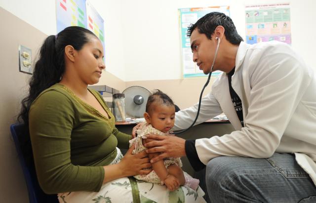 Une maman avec son enfant qui se fait ausculter par un médecin