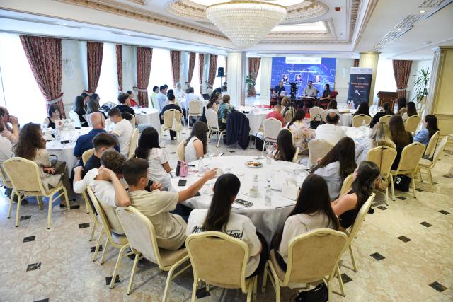 Conference room with people sitting and listening to a panel discussion
