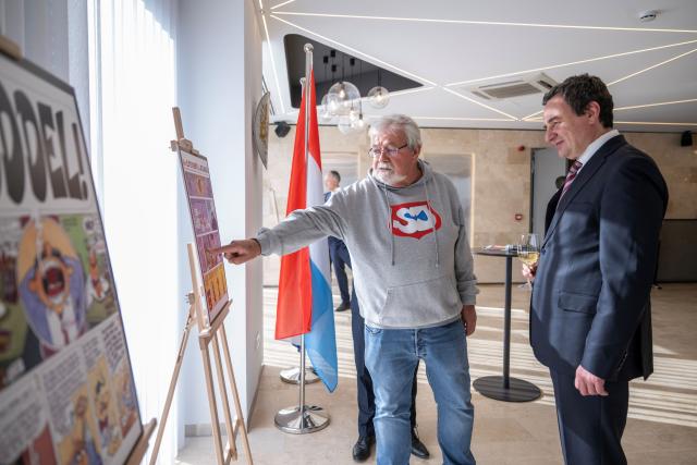 Artists explaining comic illustrations to acting Prime Minister Albin Kurti 