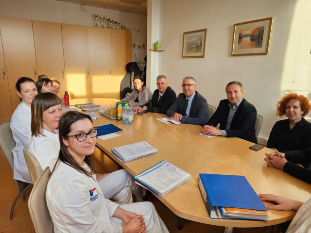 Personnes assises autour d'une table dans une salle de réunion partageant des expériences