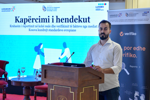 Person presenting at booth during conference