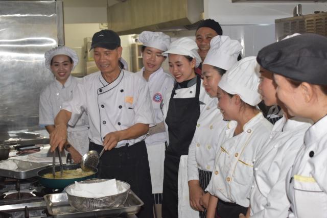 A cooking class around a chef teaching vietnamese cooking techniques
