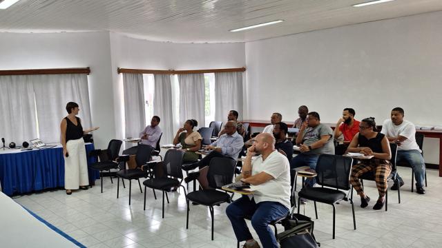 Hommes et femmes assistant à une présentation dans une salle de conférence