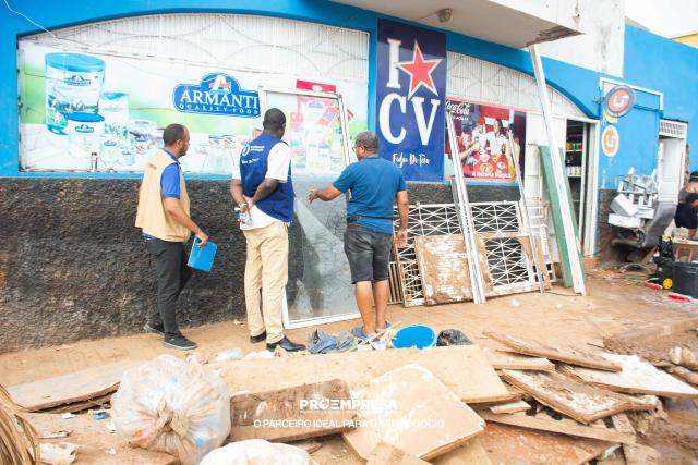 Trois hommes évaluant des dégâts devant un magasin